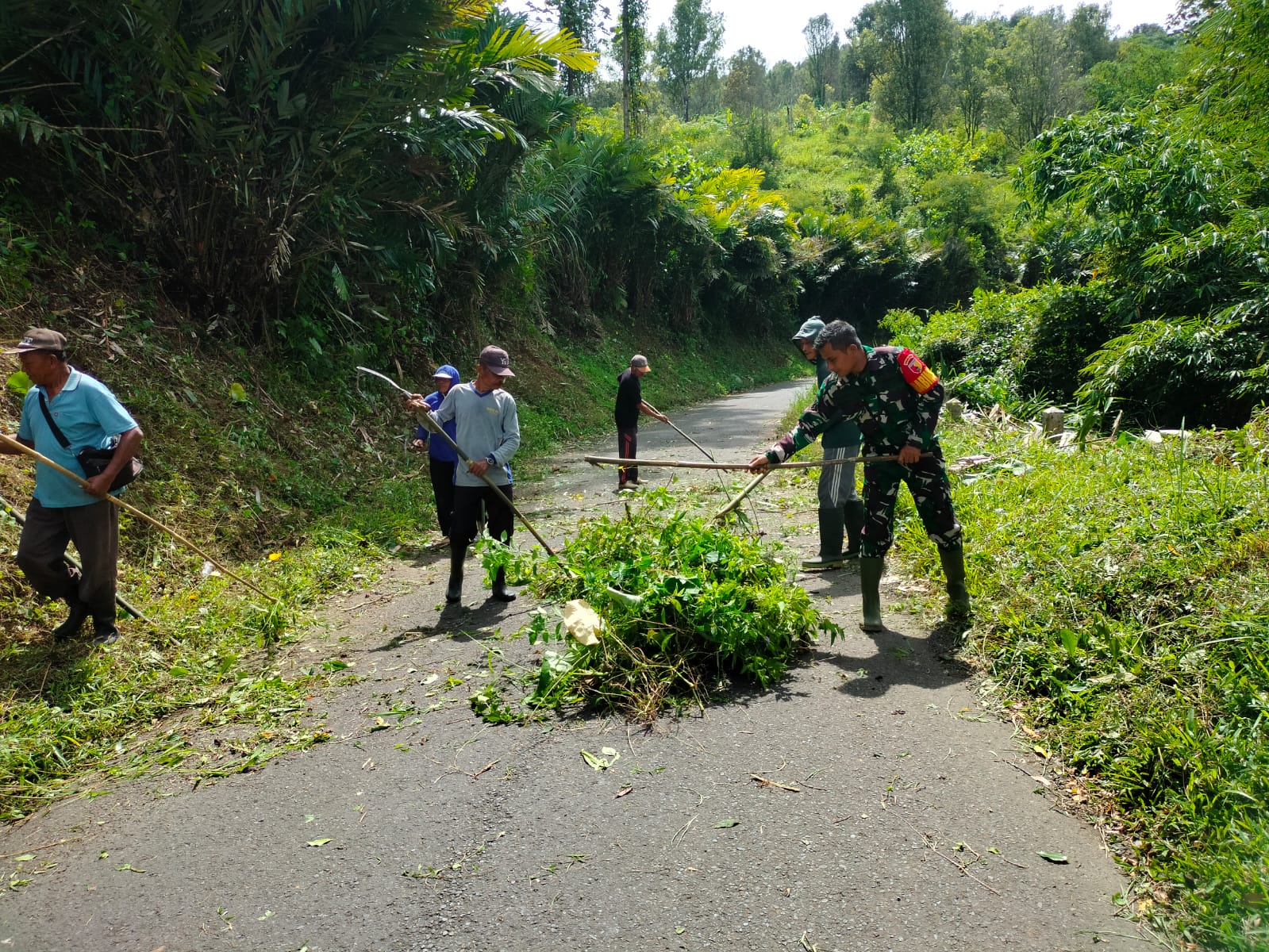 01 Sinergi Tanpa Batas, Babinsa Sidorejo Bersama Warga Bersihkan Rumput Tebing Demi Keselamatan Penguna Jalan